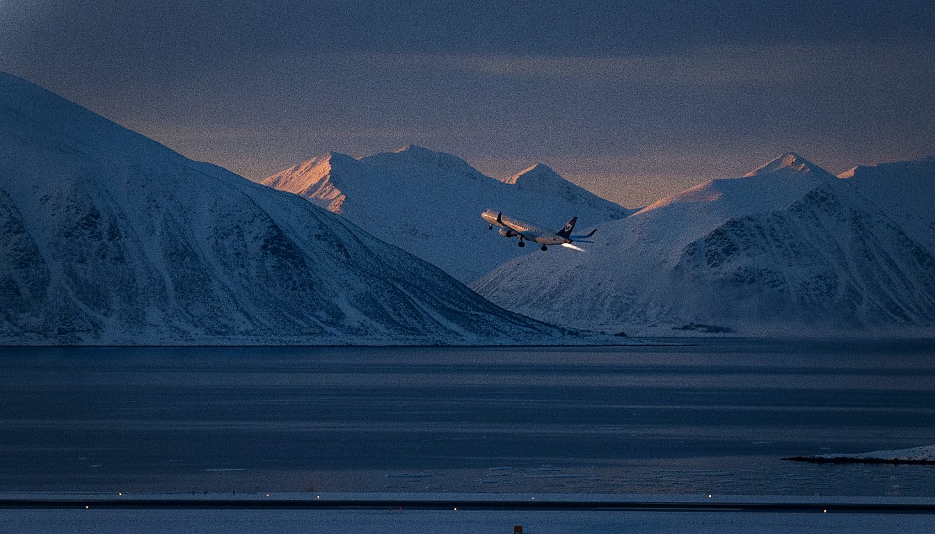 Avion au décollage sur fond de montagnes enneigées arctiques