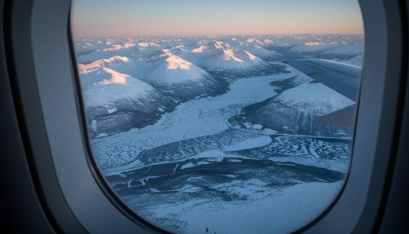 Vue depuis le hublot d'un avion survolant les montagnes enneigées de Norvège du Nord